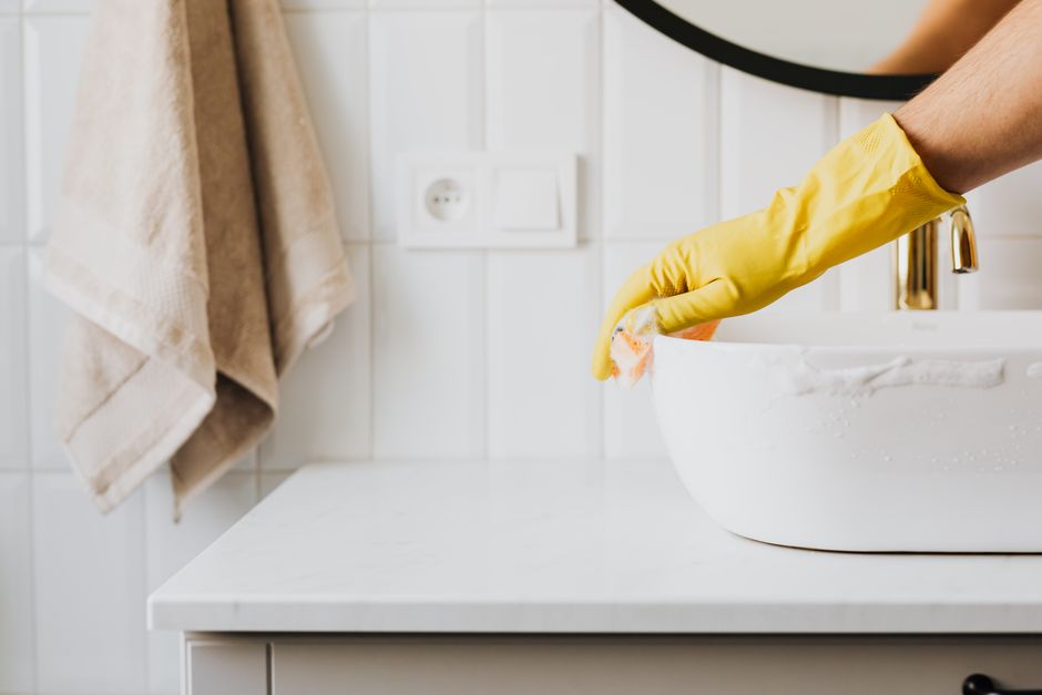 Sanitizing and wiping down a bathroom sink for a move-out clean